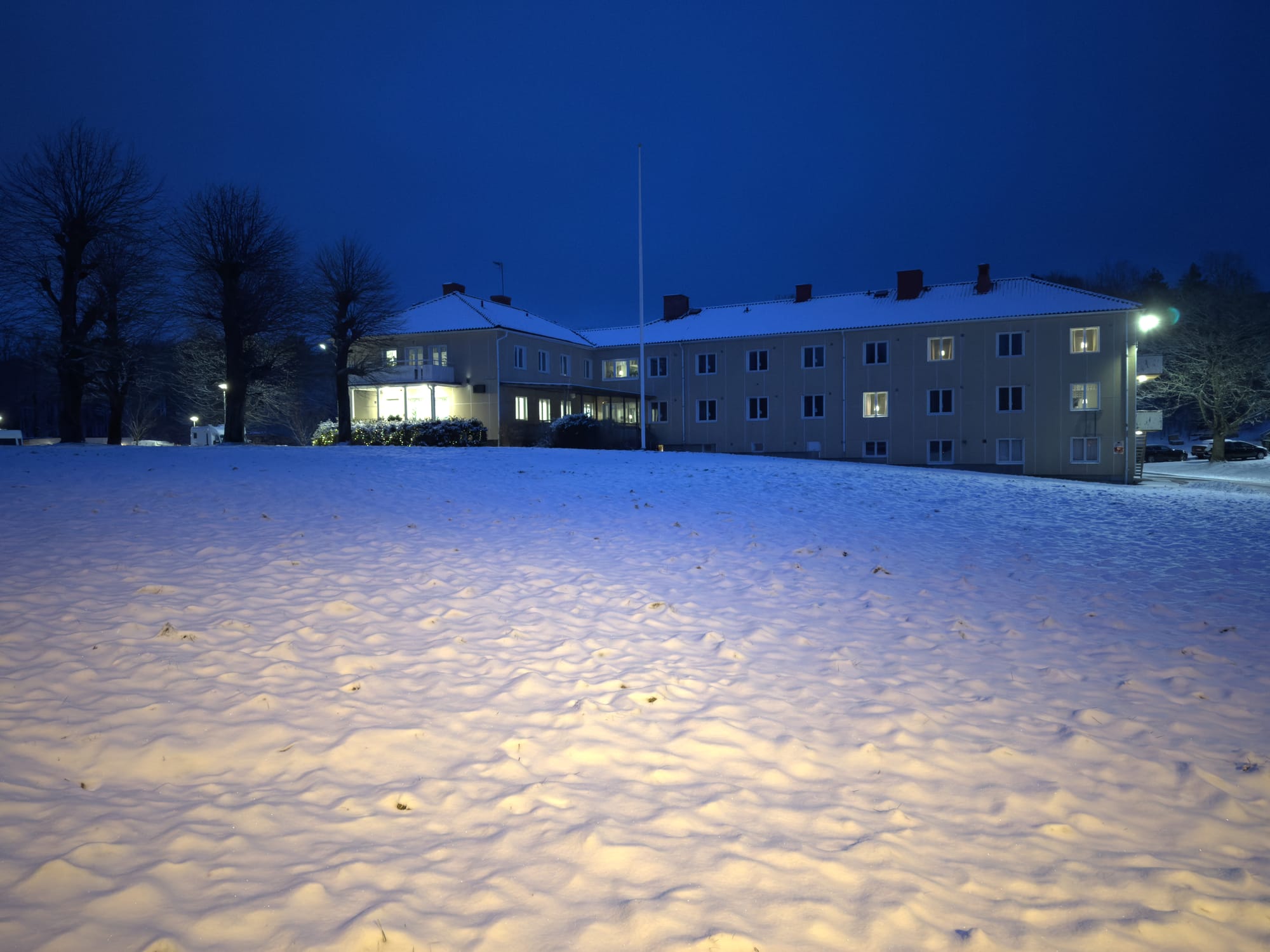 A picture of a large hostel building in winter time with snow all around.